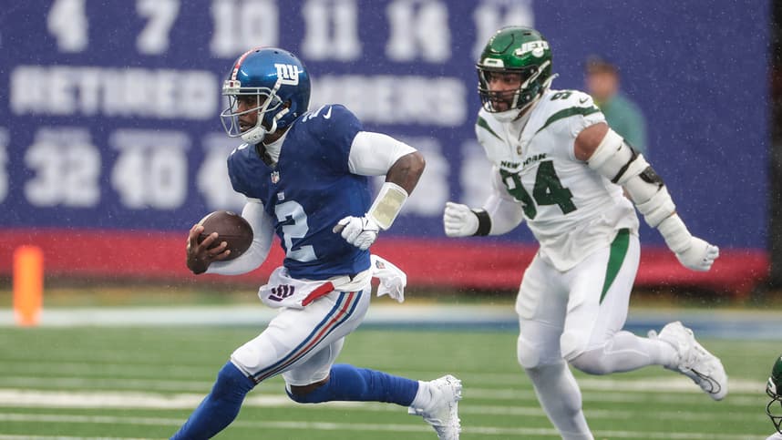New York Giants quarterback Tyrod Taylor (2) carries the ball in front of New York Jets defensive end Solomon Thomas (94) during the first half at MetLife Stadium