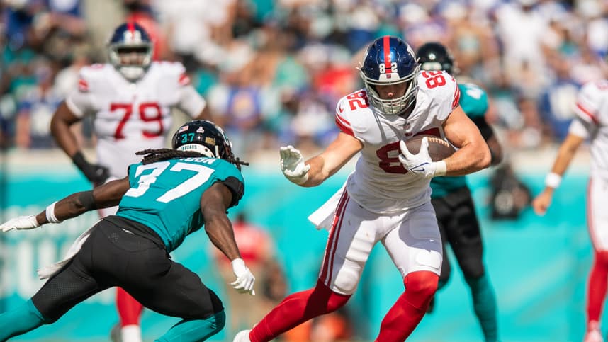 Oct 23, 2022; Jacksonville, Florida, USA;  New York Giants tight end Daniel Bellinger (82) catches the ball against Jacksonville Jaguars cornerback Tre Herndon (37) in the second quarter at TIAA Bank Field. Mandatory Credit: Jeremy Reper-USA TODAY Sports