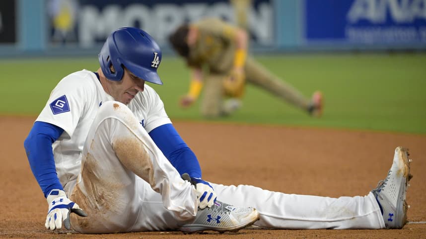 Sep 26, 2024; Los Angeles, California, USA;  Los Angeles Dodgers first baseman Freddie Freeman (5) grabs his ankle after he was injured during a play at first base in the seventh inning against the San Diego Padres at Dodger Stadium. Mandatory Credit: Jayne Kamin-Oncea-Imagn Images
