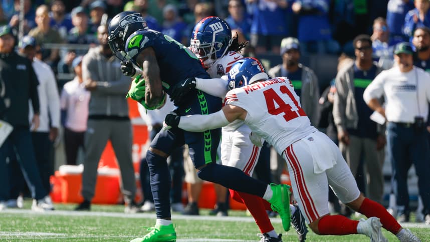 Oct 6, 2024; Seattle, Washington, USA; Seattle Seahawks wide receiver DK Metcalf (14) runs for yards after the catch against New York Giants cornerback Deonte Banks (3) and linebacker Micah McFadden (41) during the first quarter at Lumen Field. Mandatory Credit: Joe Nicholson-Imagn Images