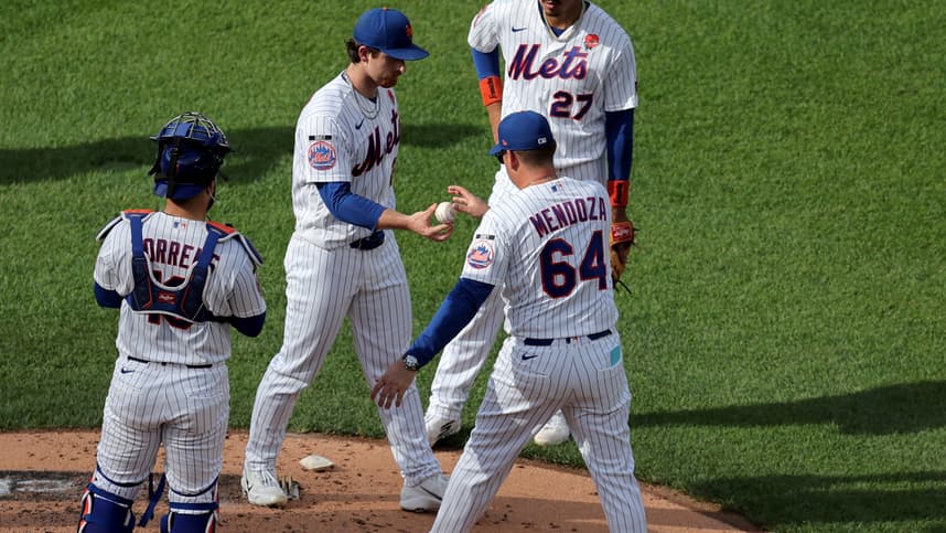 Nolan McLean hands the ball to Carlos Mendoza during a Mets pitching change