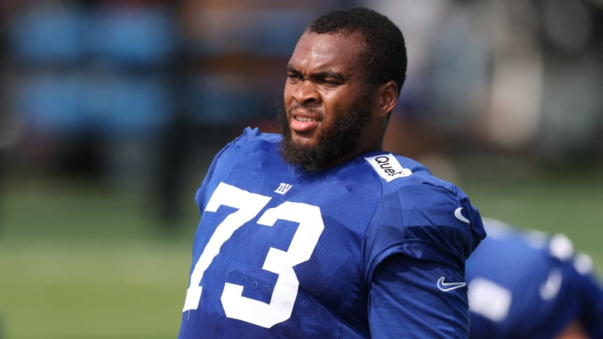 Evan Neal works on the field during Giants training camp