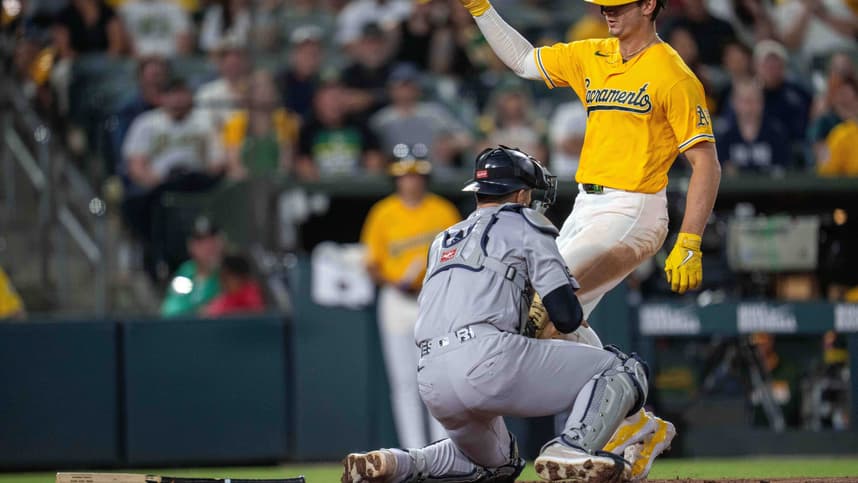 J.C. Escarra tags out a runner at home for the Yankees against the Athletics
