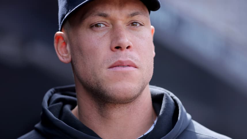 Aaron Judge stands in the Yankees dugout after a win