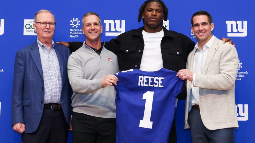 Joe Schoen and John Harbaugh pose with a Giants draft pick