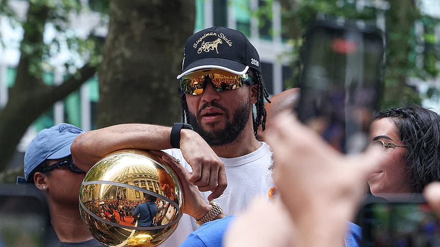 Jalen Brunson holding the championship trophy for the Knicks