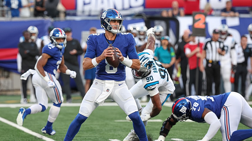 New York Giants quarterback Daniel Jones (8) drops back top pass during the first quarter as Carolina Panthers linebacker Amare Barno (90) pursues at MetLife Stadium
