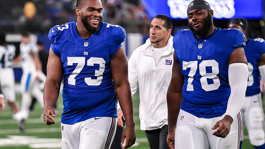 New York Giants offensive tackle Evan Neal (73) and New York Giants offensive tackle Andrew Thomas (78) exit the field after defeating the Carolina Panthers at MetLife Stadium