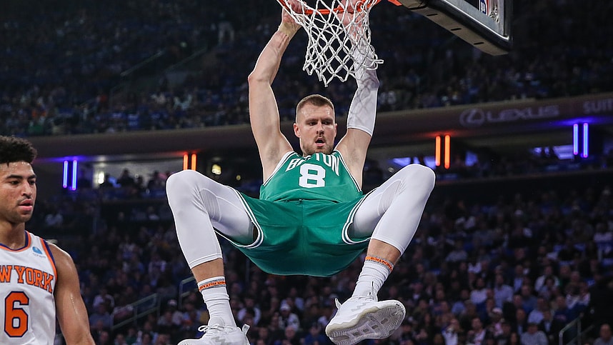 Boston Celtics center Kristaps Porzingis (8) hangs on the rim after a dunk in the first quarter against the New York Knicks at Madison Square Garden
