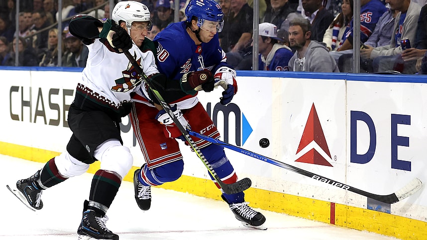 Arizona Coyotes defenseman Travis Dermott (33) and New York Rangers left wing Will Cuylle (50) fight for the puck during the second period at Madison Square Garden