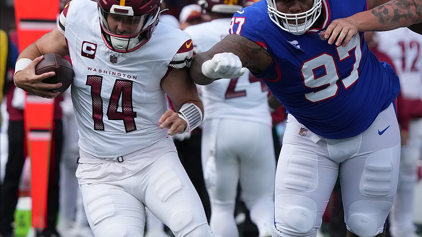 Sam Howell of the Commanders is chased by Dexter Lawrence of the Giants in the first half. The NY Giants host the Washington Commanders at MetLife Stadium in East Rutherford