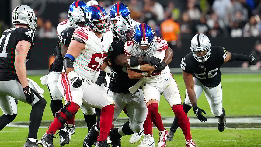 New York Giants quarterback Tommy DeVito (15) is sacked by Las Vegas Raiders defensive tackle Adam Butler (69) during the fourth quarter at Allegiant Stadium