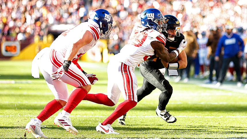 Washington Commanders quarterback Sam Howell (14) scores a touchdown as New York Giants safety Xavier McKinney (29) defends during the second quarter at FedExField