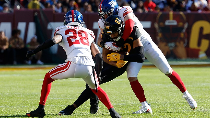 Washington Commanders tight end Logan Thomas (82) fumbles on a tackle by New York Giants linebacker Micah McFadden (41) and Giants cornerback Cor'Dale Flott (28) during the first quarter at FedExField