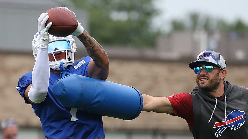 Bills cornerback Taron Johnson (7) catches the ball as he is hit by linebackers coach Bobby Babich (New York Giants defensive coordinator candidate) during interception drills on day nine of Buffalo Bills training camp