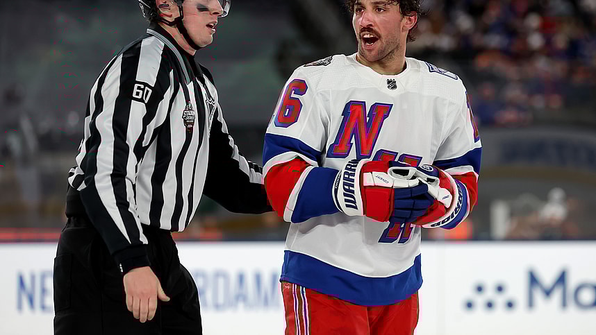 New York Rangers center Vincent Trocheck (16) is led off the ice by linesman Libor Suchanek (60) after a roughing call against Trochek and New York Islanders defenseman Alexander Romanov (not pictured) during the third period of a Stadium Series ice hockey game at MetLife Stadium