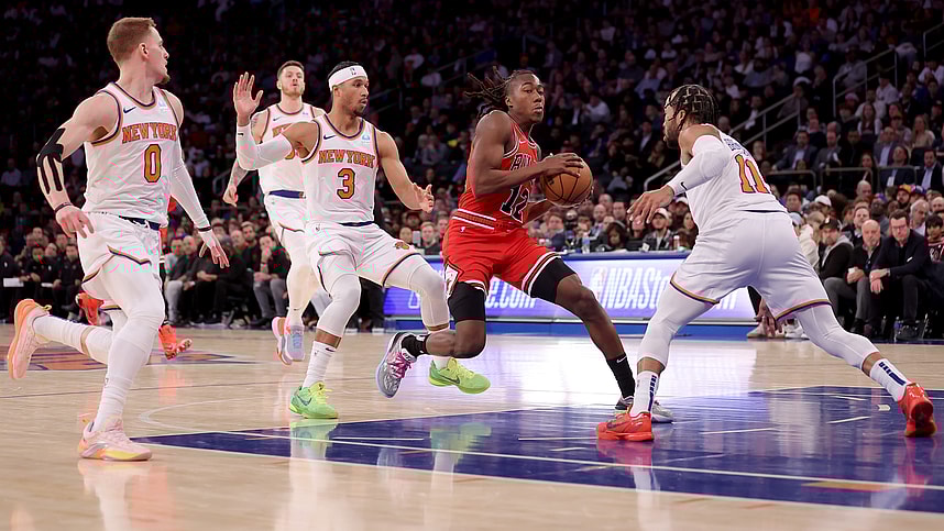 Chicago Bulls guard Ayo Dosunmu (12) drives the lane against New York Knicks guards Donte DiVincenzo (0) and Josh Hart (3) and Jalen Brunson (11) during the third quarter at Madison Square Garden