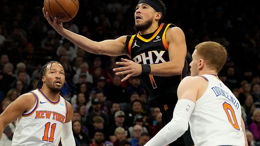 Dec 15, 2023; Phoenix, Arizona, USA; Phoenix Suns guard Devin Booker (1) drives between New York Knicks guard Jalen Brunson (11) and guard Donte DiVincenzo (0) in the first half at Footprint Center. Mandatory Credit: Rick Scuteri-USA TODAY Sports