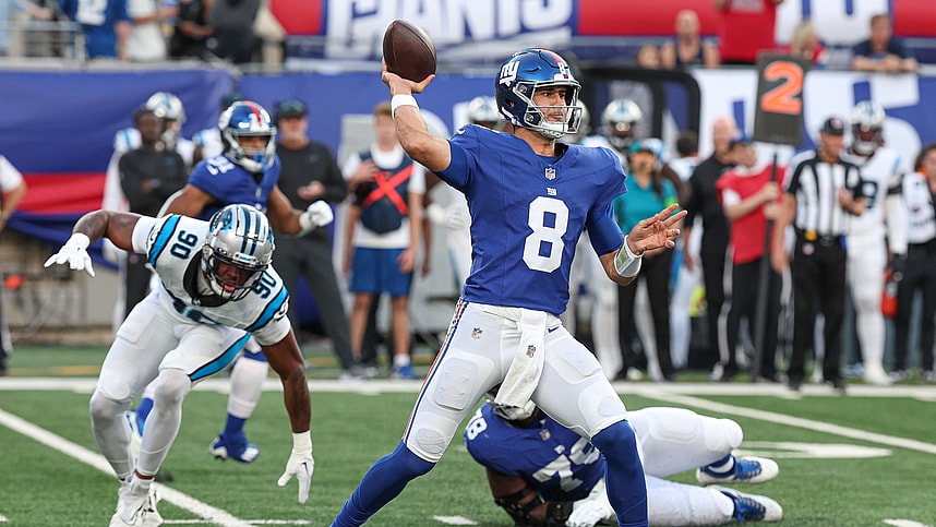 Aug 18, 2023; East Rutherford, New Jersey, USA; New York Giants quarterback Daniel Jones (8) throws the ball during the first quarter as Carolina Panthers linebacker Amare Barno (90) pursues at MetLife Stadium. Mandatory Credit: Vincent Carchietta-USA TODAY Sports