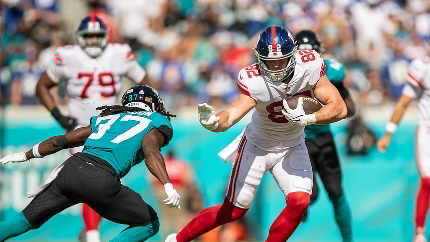 Oct 23, 2022; Jacksonville, Florida, USA;  New York Giants tight end Daniel Bellinger (82) catches the ball against Jacksonville Jaguars cornerback Tre Herndon (37) in the second quarter at TIAA Bank Field. Mandatory Credit: Jeremy Reper-USA TODAY Sports