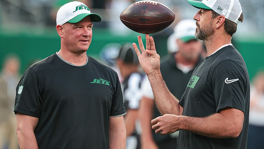 Aug 24, 2024; East Rutherford, New Jersey, USA; New York Jets quarterback Aaron Rodgers (left) spins the ball in front of offensive coordinator Nathaniel Hackett before the game against the New York Giants at MetLife Stadium. Mandatory Credit: Vincent Carchietta-Imagn Images
