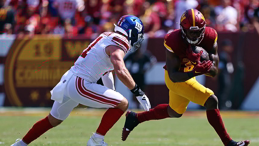 Sep 15, 2024; Landover, Maryland, USA; Washington Commanders running back Brian Robinson Jr. (8) runs the ball against New York Giants linebacker Micah McFadden (41) during the first quarter at Commanders Field. Mandatory Credit: Peter Casey-Imagn Images