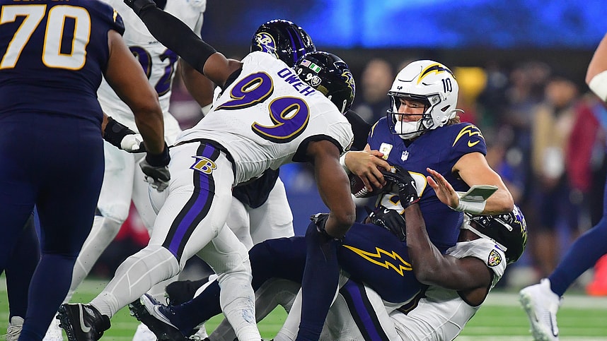 Nov 25, 2024; Inglewood, California, USA; Los Angeles Chargers quarterback Justin Herbert (10) is sacked by Baltimore Ravens cornerback Brandon Stephens (21) and linebacker Odafe Oweh (99) during the second half at SoFi Stadium. Mandatory Credit: Gary A. Vasquez-Imagn Images