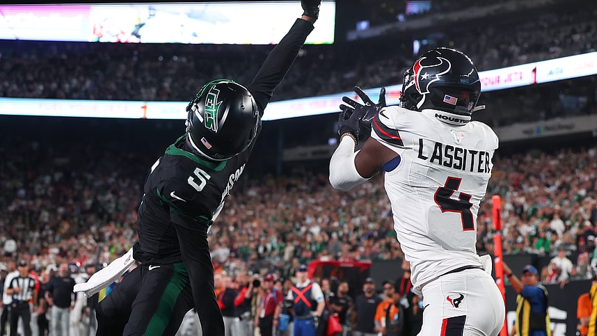 Oct 31, 2024; East Rutherford, New Jersey, USA; New York Jets wide receiver Garrett Wilson (5) catches a touchdown pass while being defended by Houston Texans cornerback Kamari Lassiter (4) during the second half at MetLife Stadium. Mandatory Credit: Ed Mulholland-Imagn Images