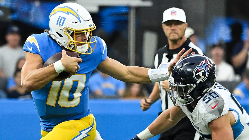 Nov 10, 2024; Inglewood, California, USA; Los Angeles Chargers quarterback Justin Herbert (10) stiff arms Tennessee Titans linebacker Jack Gibbens (50) during the second quarter at SoFi Stadium. Mandatory Credit: Robert Hanashiro-Imagn Images