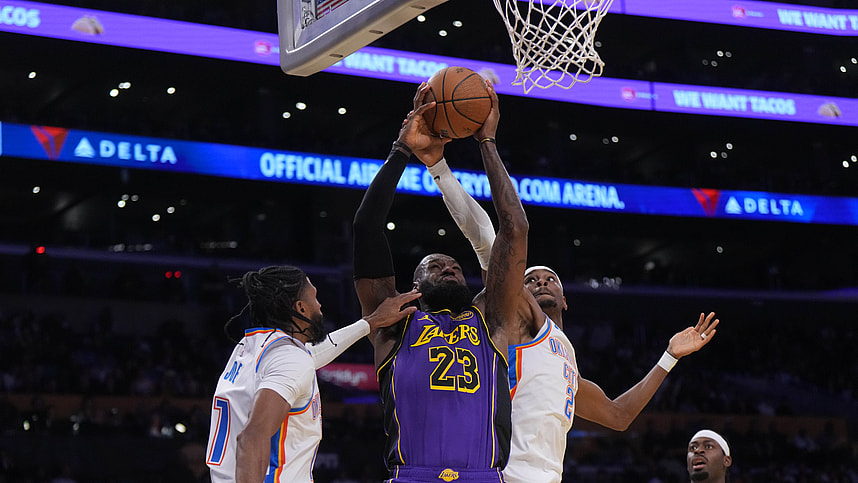 Nov 29, 2024; Los Angeles, California, USA; Los Angeles Lakers forward LeBron James (23) shoots the ball against Oklahoma City Thunder guard Shai Gilgeous-Alexander (2) and guard Isaiah Joe (11) in the first half at Crypto.com Arena. Mandatory Credit: Kirby Lee-Imagn Images