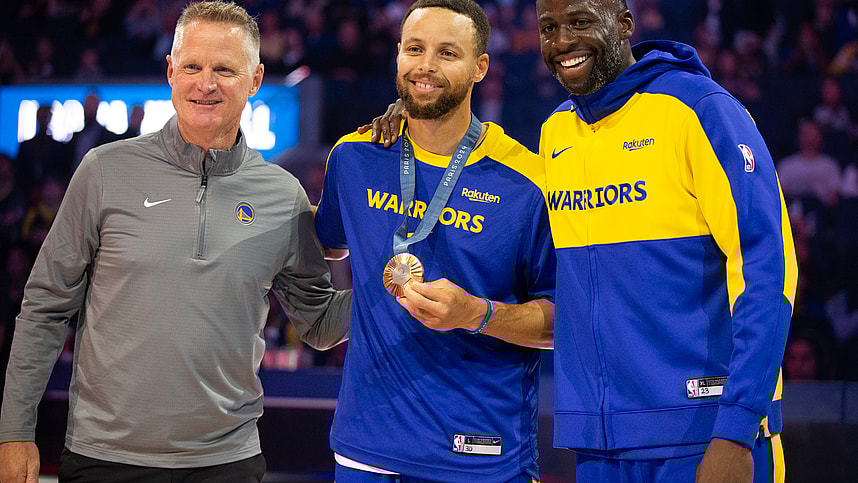 Oct 11, 2024; San Francisco, California, USA; Golden State Warriors guard Stephen Curry (center) is flanked by head coach Steve Kerr and forward Draymond Green as he is presented his gold medal for his performance for Team USA at the 2024 Summer Olympics in Paris before taking on the Sacramento Kings at Chase Center. Mandatory Credit: D. Ross Cameron-Imagn Images