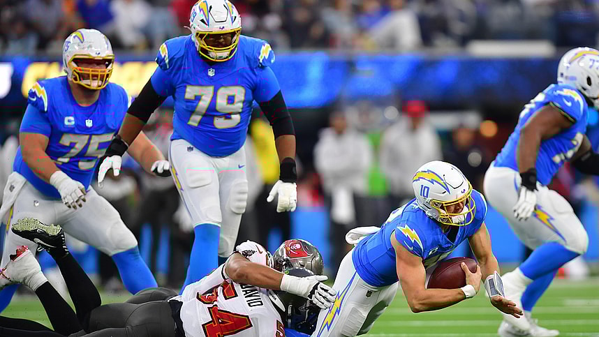 Dec 15, 2024; Inglewood, California, USA; Los Angeles Chargers quarterback Justin Herbert (10) is brought down by Tampa Bay Buccaneers linebacker Lavonte David (54) and defensive end Logan Hall (90) during the second half at SoFi Stadium. Mandatory Credit: Gary A. Vasquez-Imagn Images