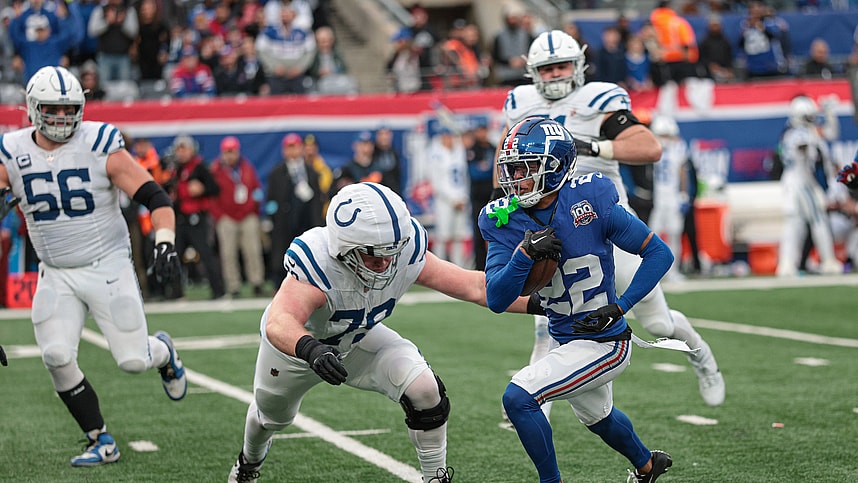 Dec 29, 2024; East Rutherford, New Jersey, USA; New York Giants cornerback Dru Phillips (22) returns an interception as Indianapolis Colts offensive tackle Bernhard Raimann (79) tackles during the second half at MetLife Stadium. Mandatory Credit: Vincent Carchietta-Imagn Images