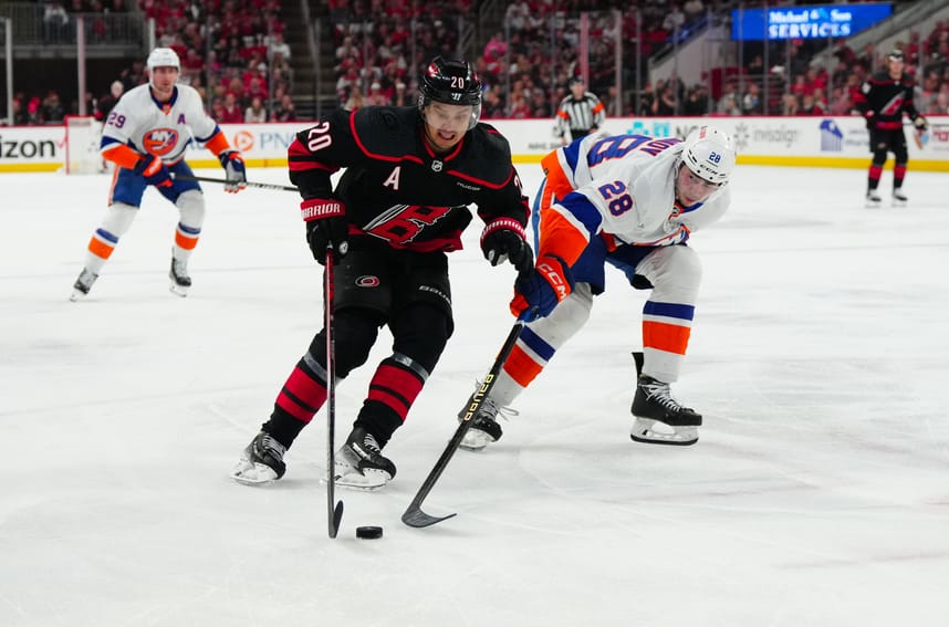 Apr 30, 2024; Raleigh, North Carolina, USA; Carolina Hurricanes center Sebastian Aho (20) skates with the puck past New York Islanders defenseman Alexander Romanov (28) during the first period in game five of the first round of the 2024 Stanley Cup Playoffs at PNC Arena. Mandatory Credit: James Guillory-USA TODAY Sports