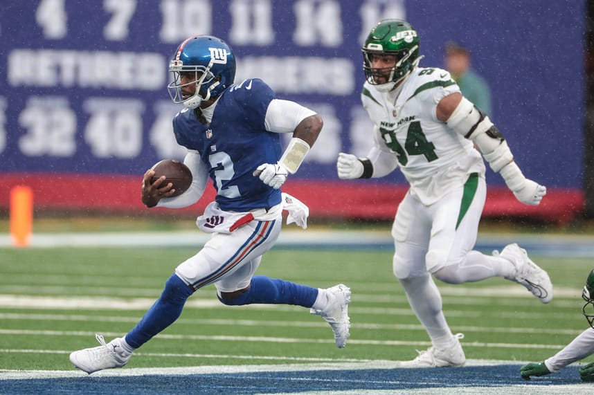 New York Giants quarterback Tyrod Taylor (2) carries the ball in front of New York Jets defensive end Solomon Thomas (94) during the first half at MetLife Stadium