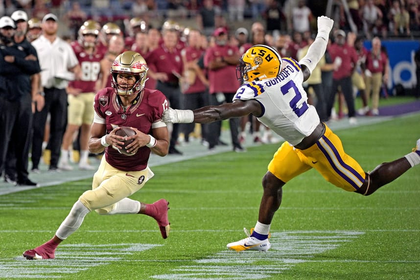 Sep 3, 2023; Orlando, Florida, USA; Florida State Seminoles quarterback Jordan Travis (13) runs away from  Louisiana State Tigers linebacker Ovie Oghoufo (2) during the second half at Camping World Stadium. Mandatory Credit: Melina Myers-USA TODAY Sports