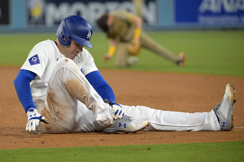 Sep 26, 2024; Los Angeles, California, USA;  Los Angeles Dodgers first baseman Freddie Freeman (5) grabs his ankle after he was injured during a play at first base in the seventh inning against the San Diego Padres at Dodger Stadium. Mandatory Credit: Jayne Kamin-Oncea-Imagn Images