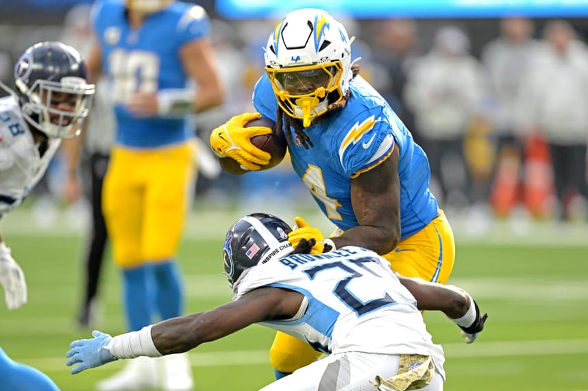 Nov 10, 2024; Inglewood, California, USA; Los Angeles Chargers running back Gus Edwards (4) carries the ball for a first down before he is stopped by Tennessee Titans cornerback Jarvis Brownlee Jr. (29) in the first half at SoFi Stadium. Mandatory Credit: Jayne Kamin-Oncea-Imagn Images