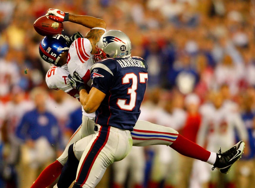 Giants receiver David Tyree catches a pass while in the clutches of Patriots safety Rodney Harrison en route to New York's 17-14
