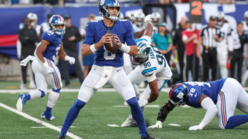 New York Giants quarterback Daniel Jones (8) drops back top pass during the first quarter as Carolina Panthers linebacker Amare Barno (90) pursues at MetLife Stadium