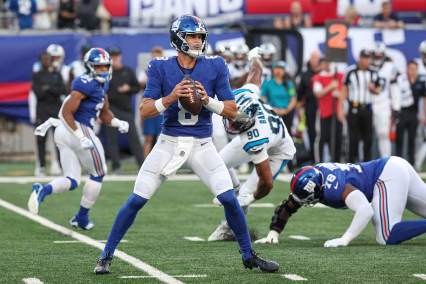 New York Giants quarterback Daniel Jones (8) drops back top pass during the first quarter as Carolina Panthers linebacker Amare Barno (90) pursues at MetLife Stadium