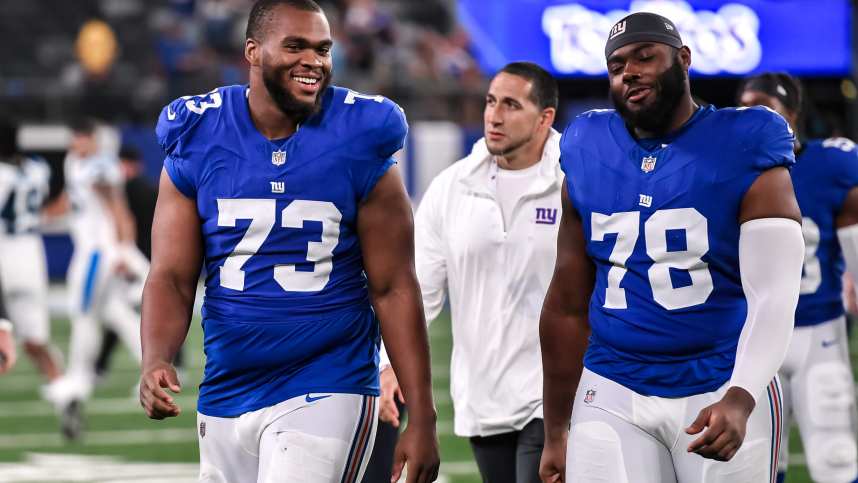 New York Giants offensive tackle Evan Neal (73) and New York Giants offensive tackle Andrew Thomas (78) exit the field after defeating the Carolina Panthers at MetLife Stadium