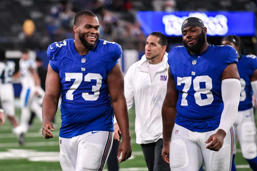 New York Giants offensive tackle Evan Neal (73) and New York Giants offensive tackle Andrew Thomas (78) exit the field after defeating the Carolina Panthers at MetLife Stadium