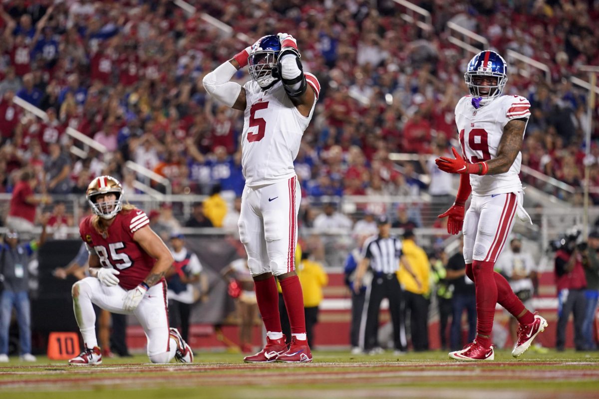 New York Giants runningback Tiki Barber leaps over defenders in