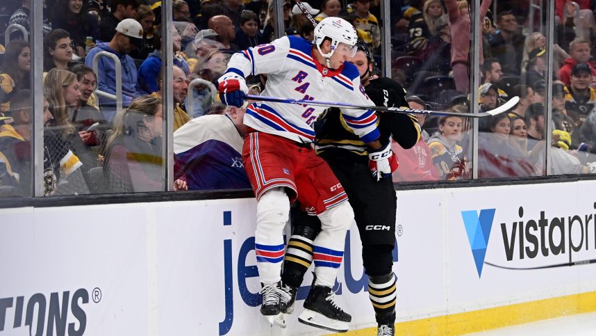 Boston Bruins defenseman Alec Regula (75) gets checked by New York Rangers left wing Will Cuylle (50) during the second period at TD Garden
