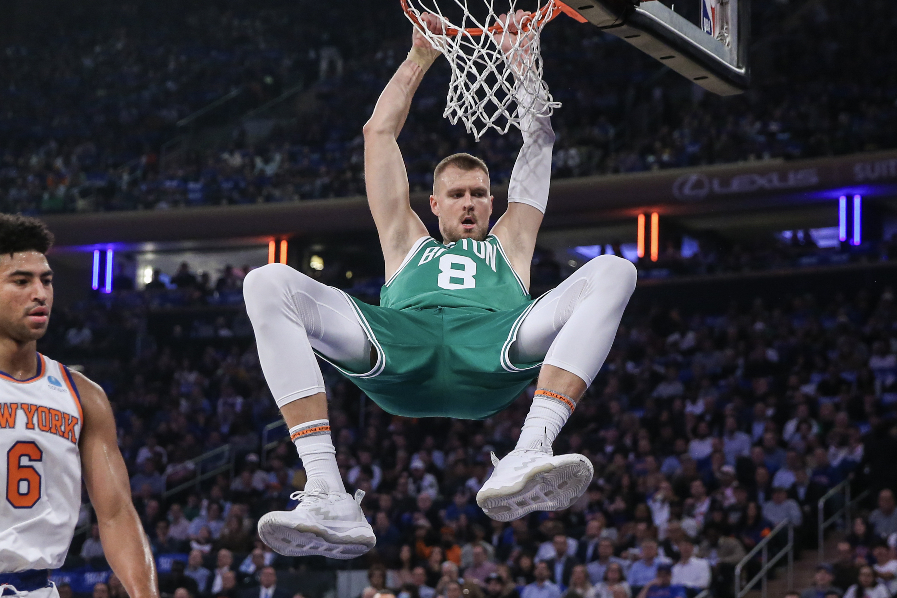 Boston Celtics center Kristaps Porzingis (8) hangs on the rim after a dunk in the first quarter against the New York Knicks at Madison Square Garden