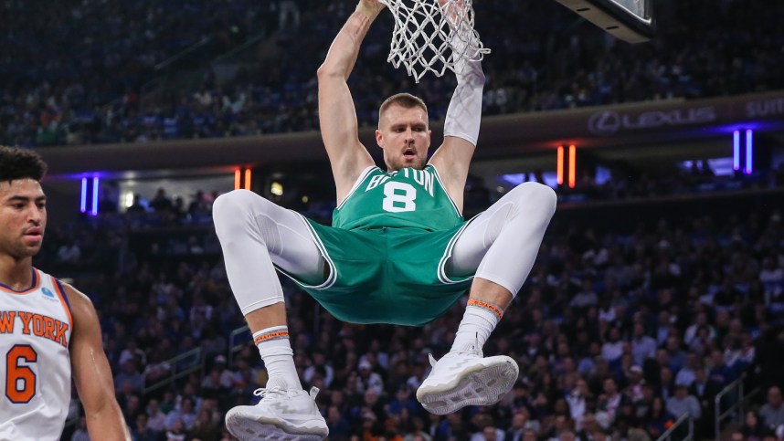 Boston Celtics center Kristaps Porzingis (8) hangs on the rim after a dunk in the first quarter against the New York Knicks at Madison Square Garden