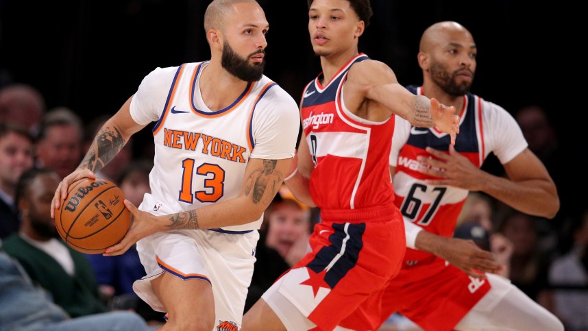 New York Knicks guard Evan Fournier (13) controls the ball against Washington Wizards guard Ryan Rollins (9) and forward Taj Gibson (67) during the fourth quarter at Madison Square Garden