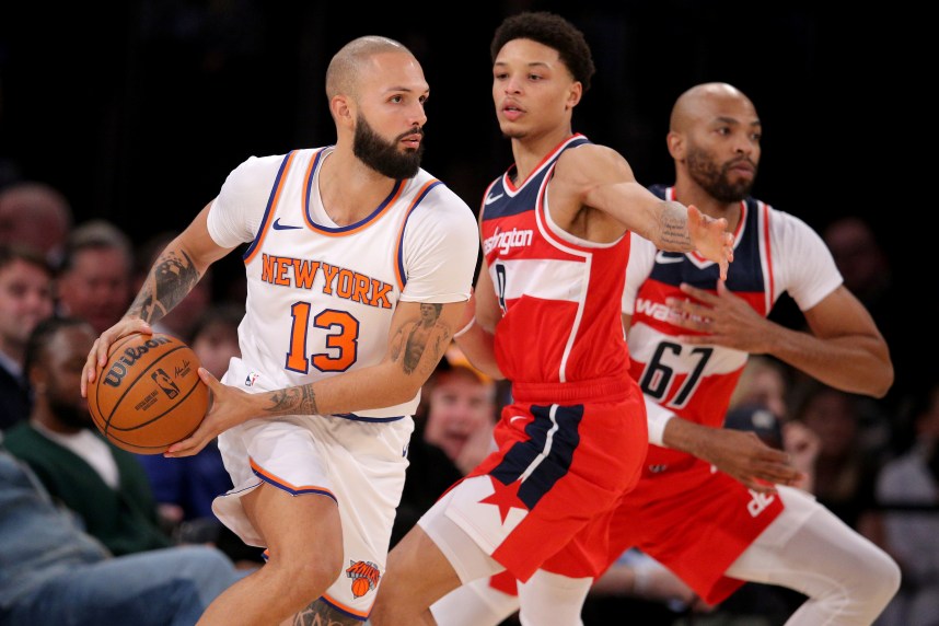 New York Knicks guard Evan Fournier (13) controls the ball against Washington Wizards guard Ryan Rollins (9) and forward Taj Gibson (67) during the fourth quarter at Madison Square Garden