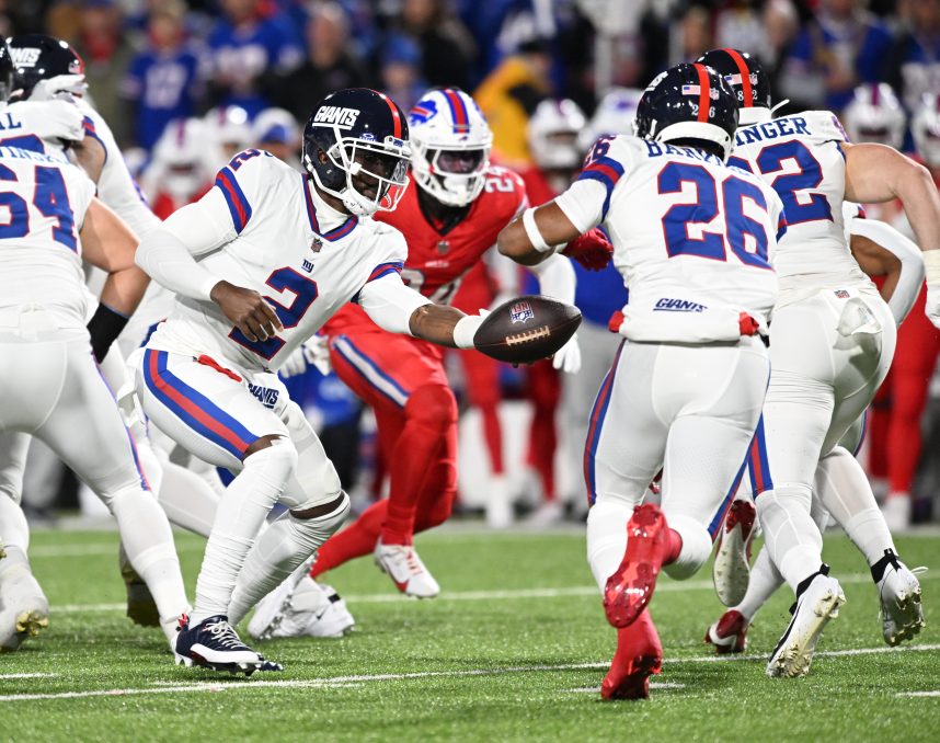 New York Giants quarterback Tyrod Taylor (2) hands off to running back Saquon Barkley (26) in the first quarter at Highmark Stadium
